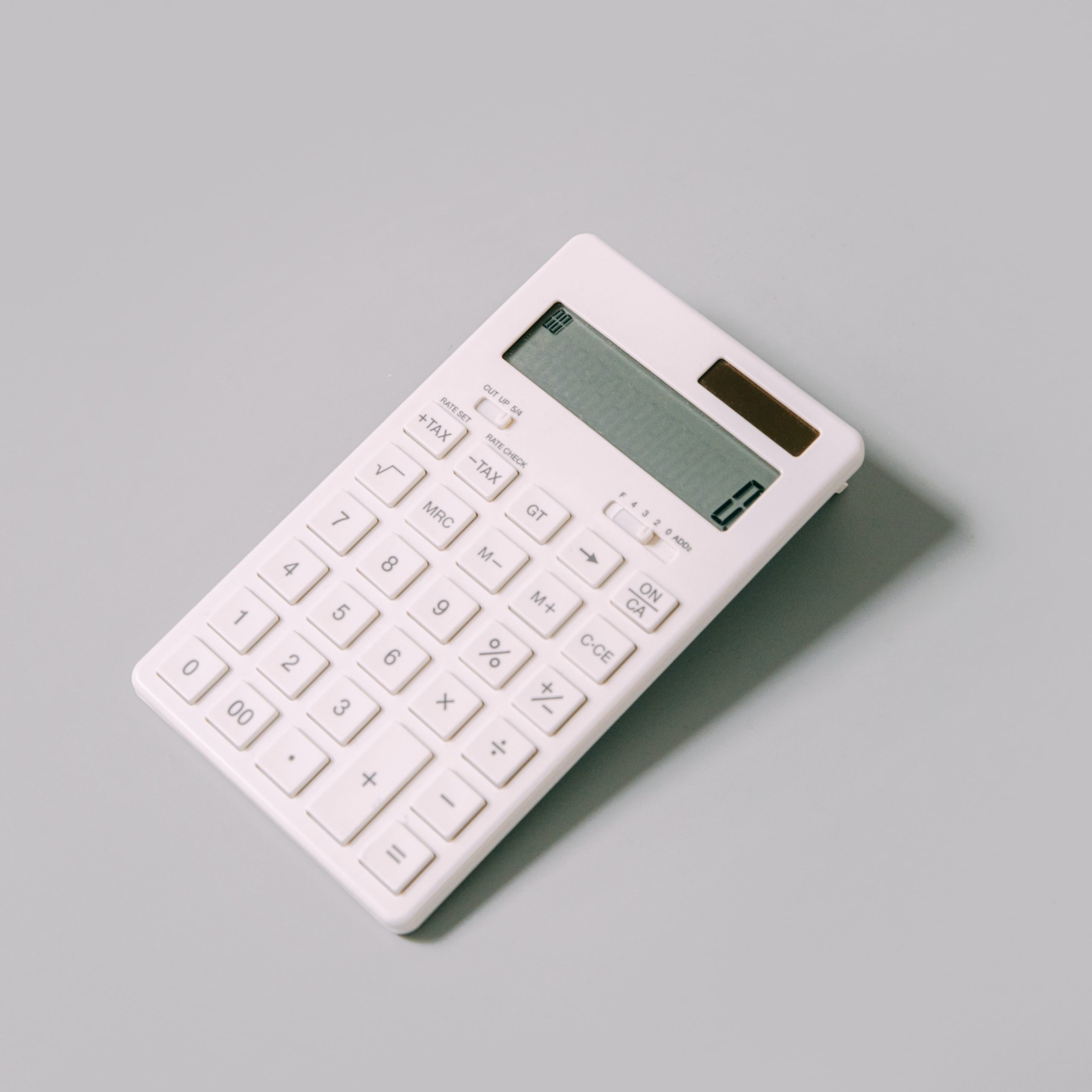 A white calculator on a grey background
